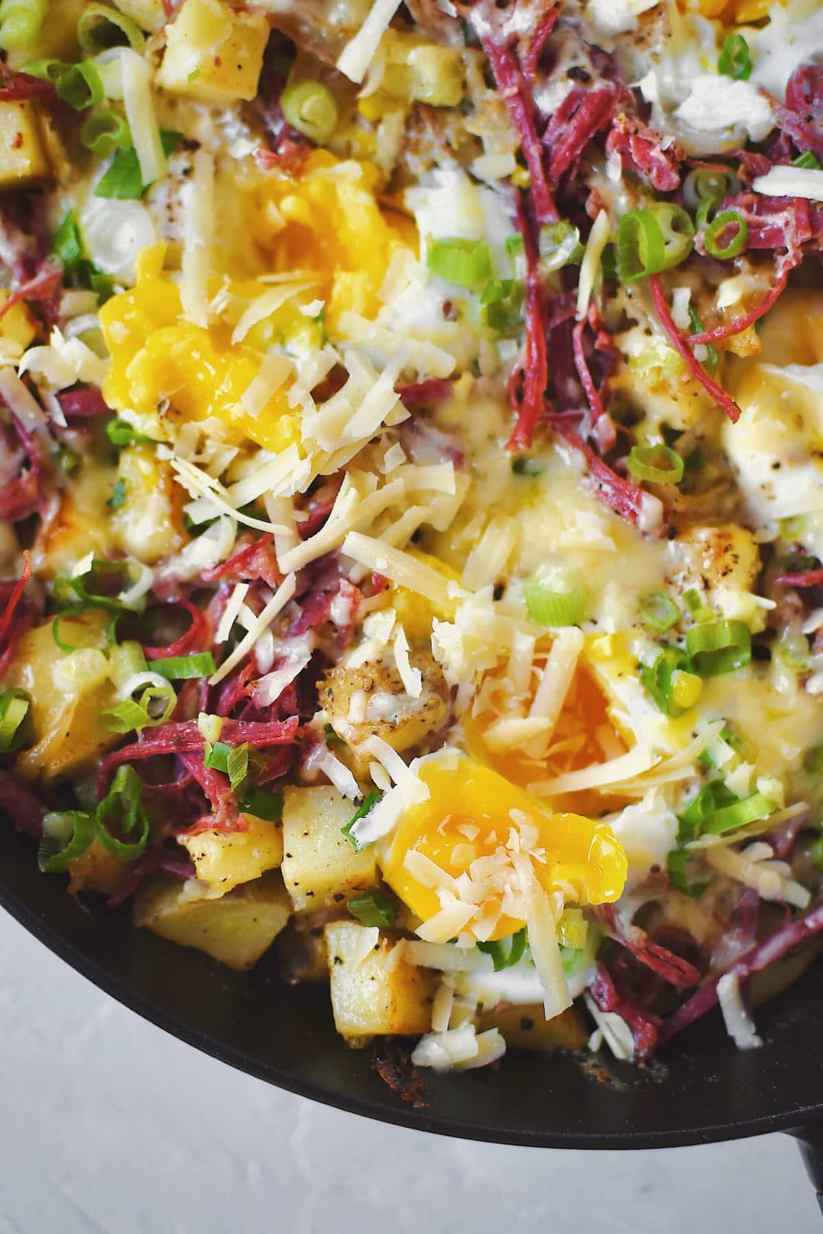 Eggs cracked into the corned beef hash, and cooked just till the whites have set, yolks opened to run out into the hash.