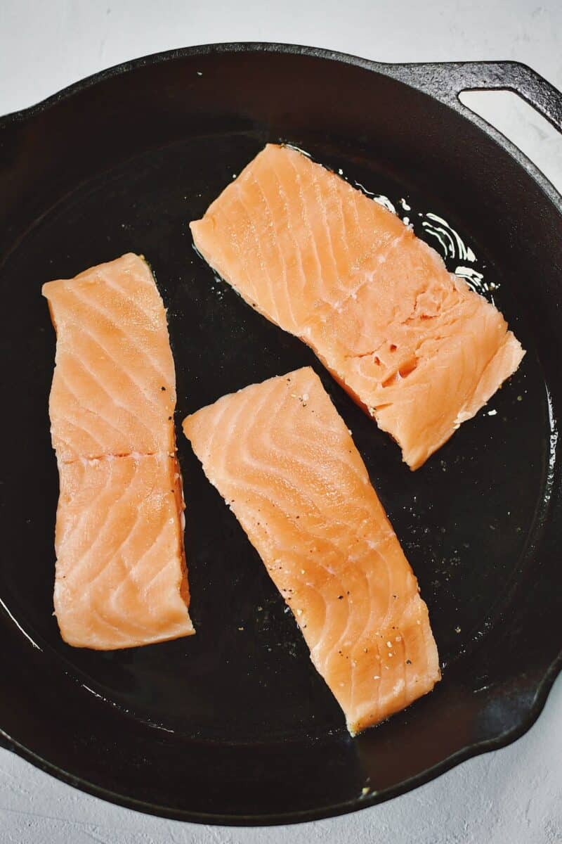 Salmon fillets, laid skin side down in a screaming hot cast iron pan with a little olive oil.