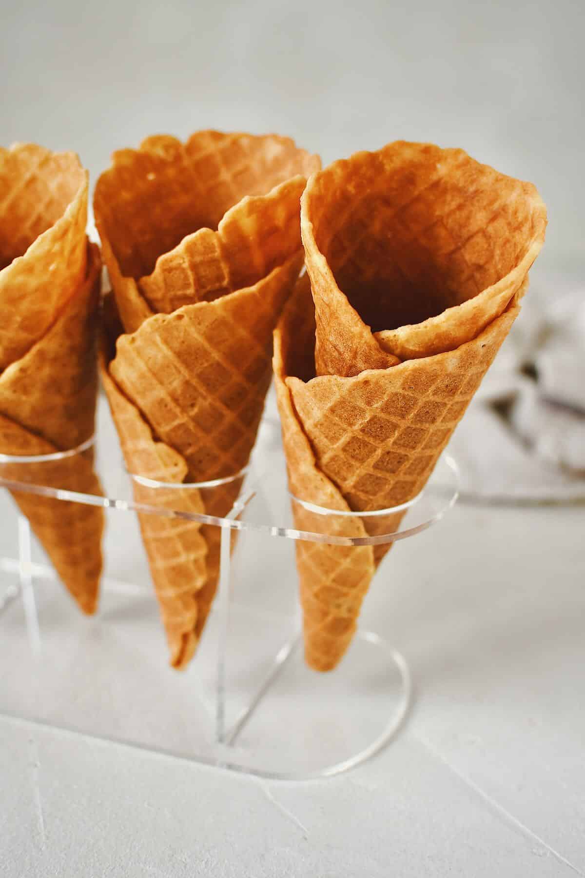 Finished Waffle Cone Recipe resting in a stand and ready to be filled with ice cream.