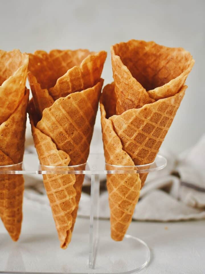 Finished Waffle Cone Recipe resting in a stand and ready to be filled with ice cream.