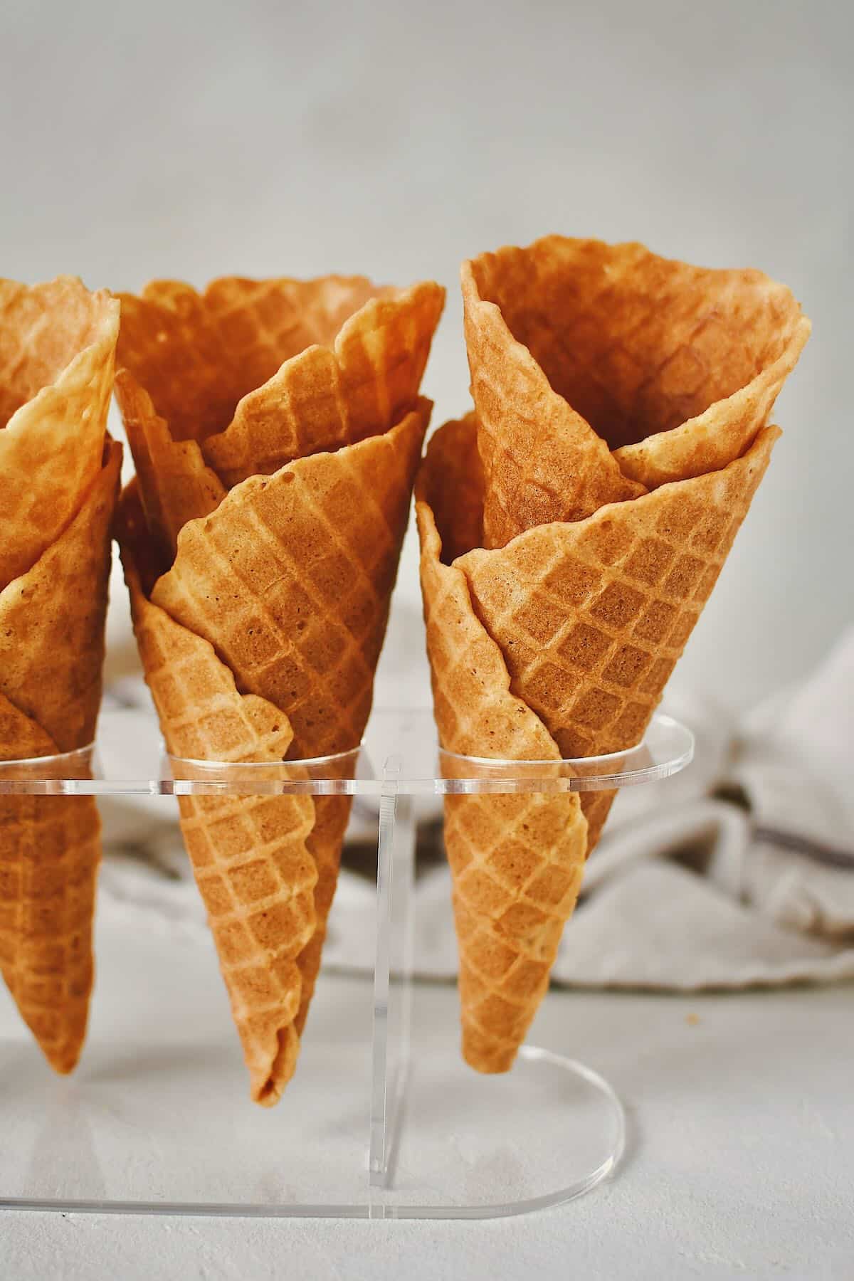 Finished Waffle Cone Recipe resting in a stand and ready to be filled with ice cream.