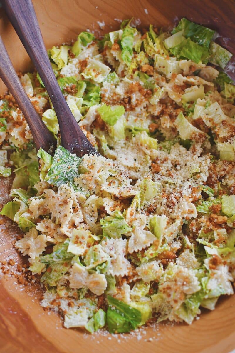 Tossing the pasta, lettuce, and crumbs together in a large bowl.