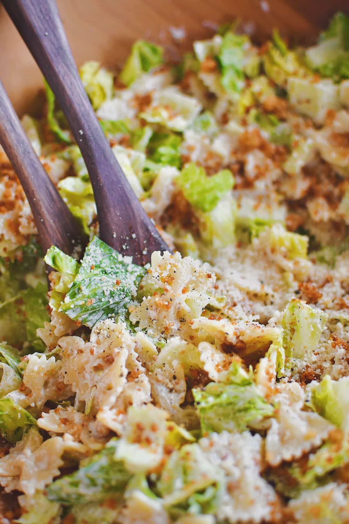 Tossing the pasta, lettuce, and crumbs together in a large bowl.