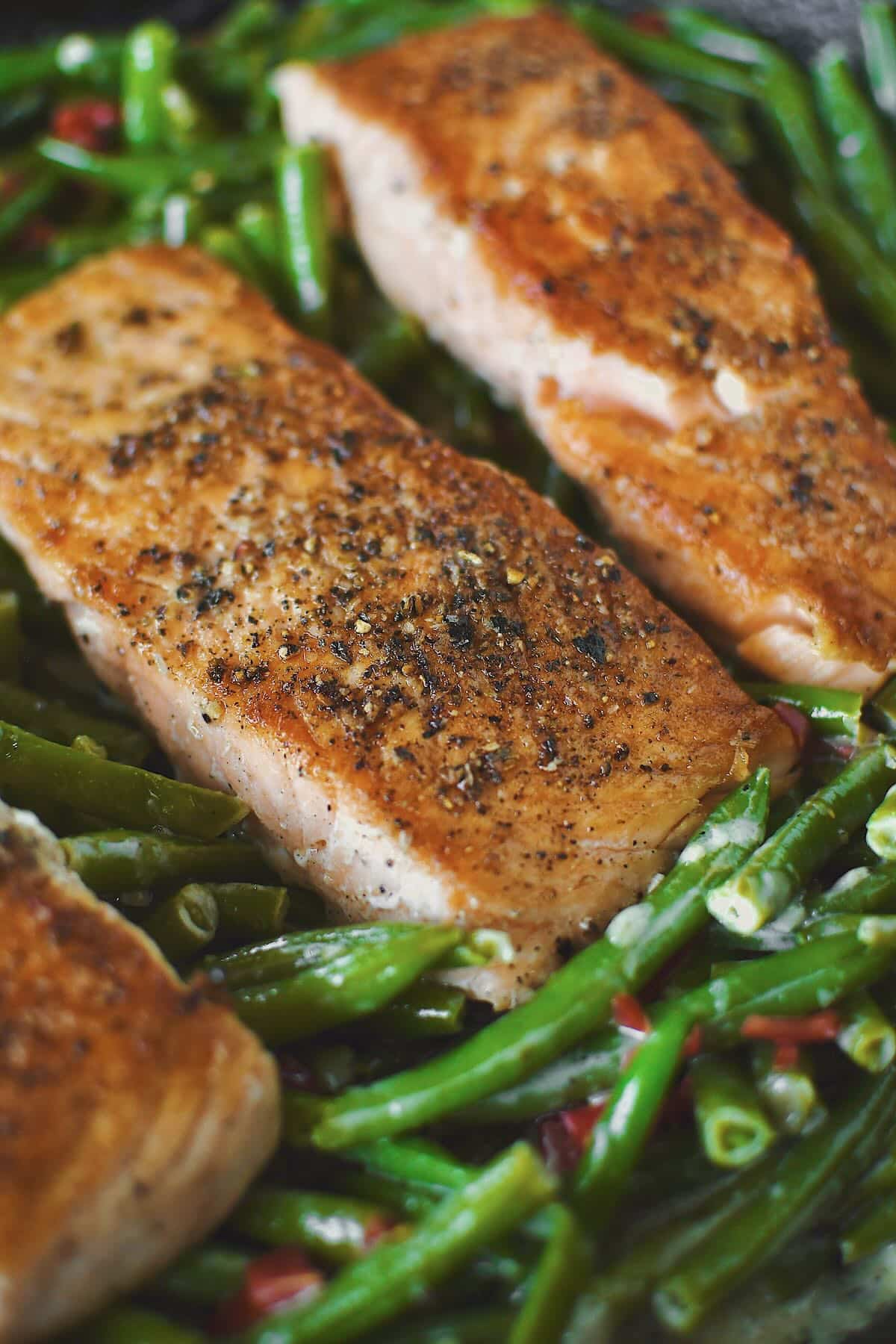 Pan Seared Salmon fillets nestled into some sauteed green beans.