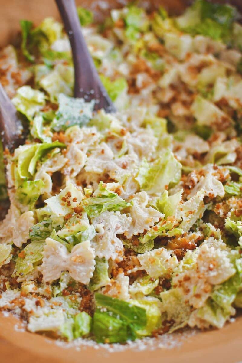 Tossing the pasta, lettuce, and crumbs together in a large bowl.