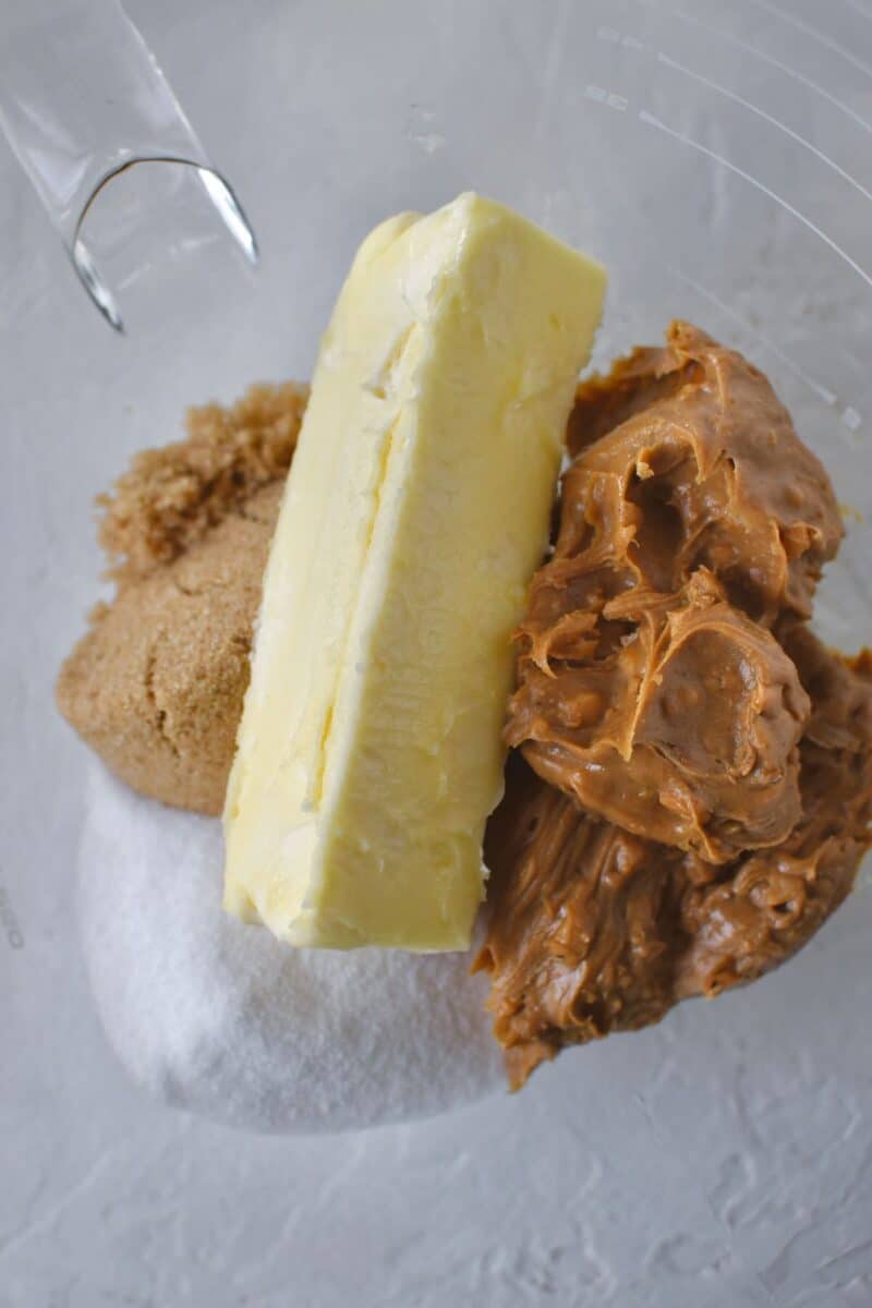 Butter, peanut butter, and sugars in a the bowl of a stand mixer ready to be creamed together.