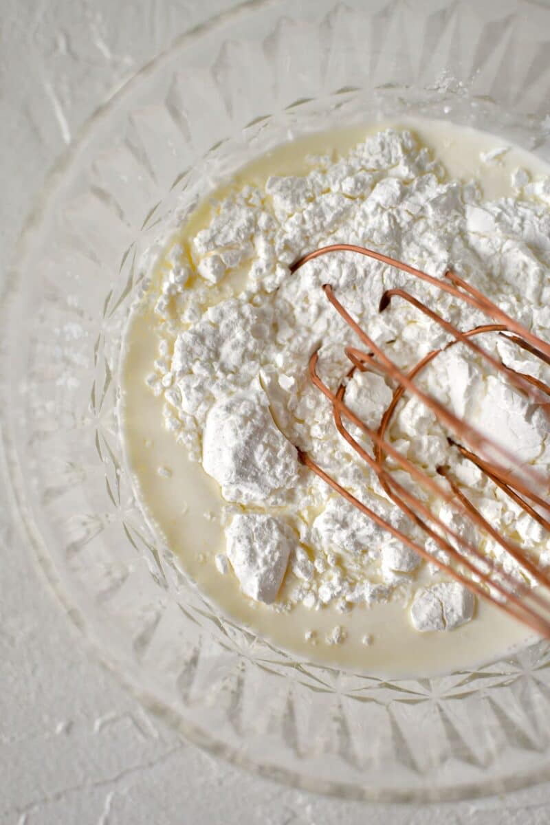 whisking together cornstarch and cream to make a slurry.