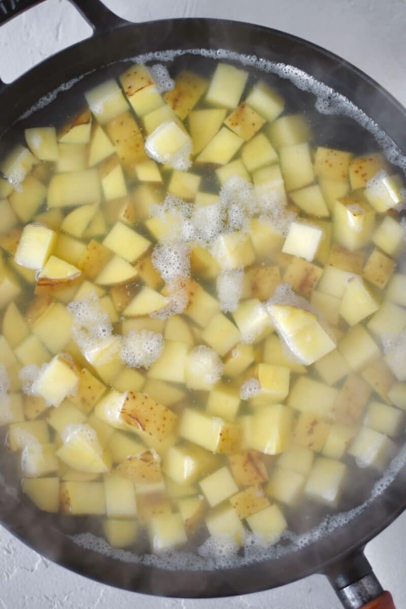 Boiling diced potatoes to par cook for corned beef hash.