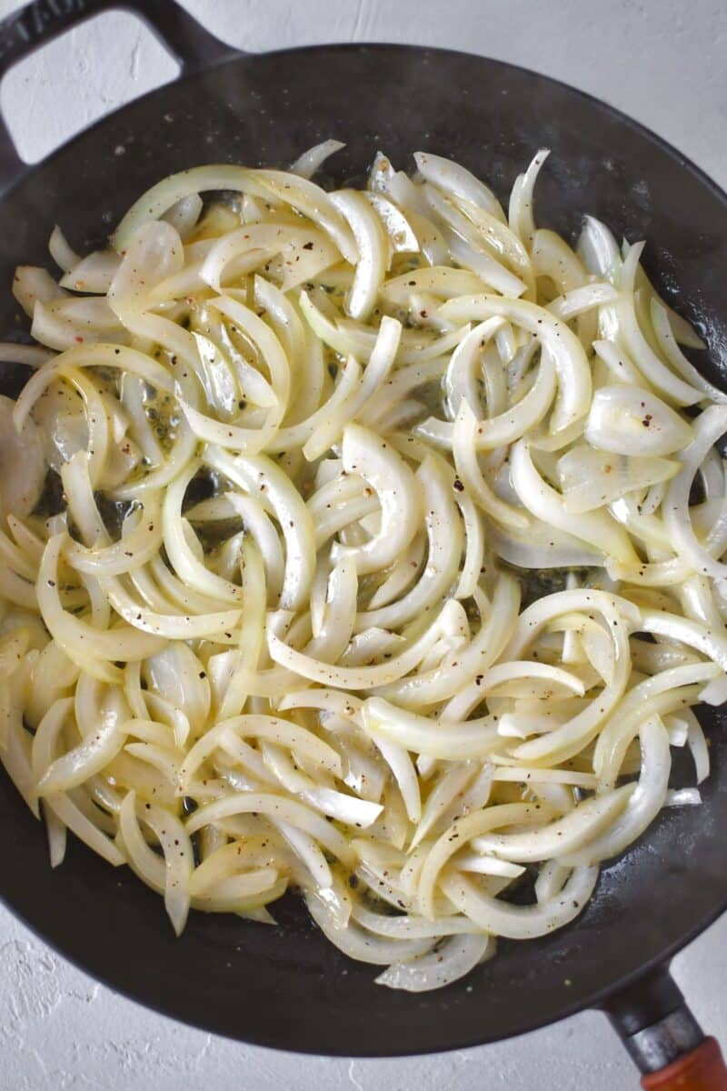 Cooking sliced onions in butter till soft.