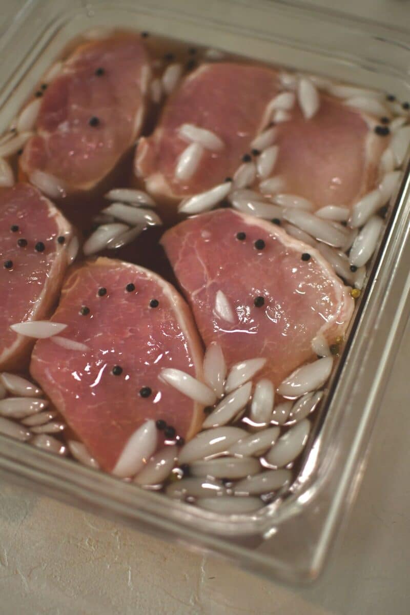 Pork chops submerged in the cooled brine.