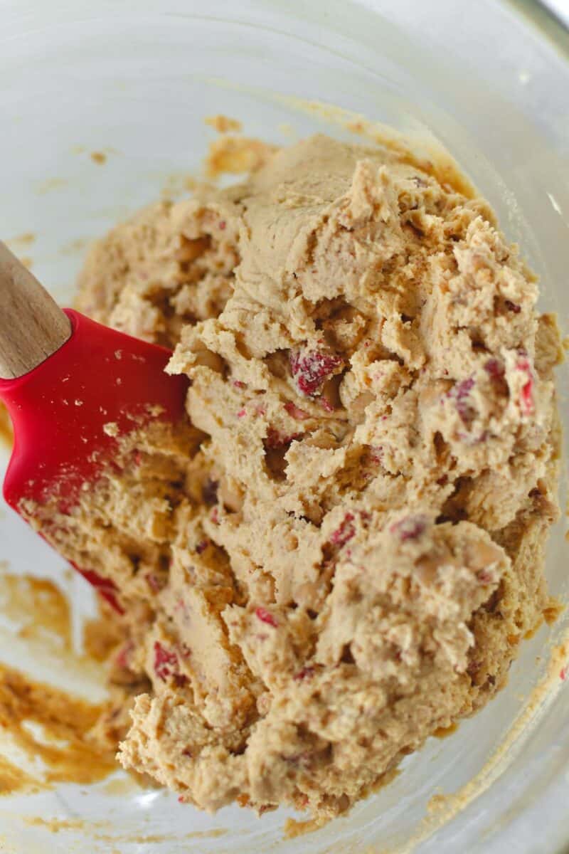 Dry ingredients added to the bowl after mixing into the wet, adding the freeze-dried strawberries and peanut butter chips.