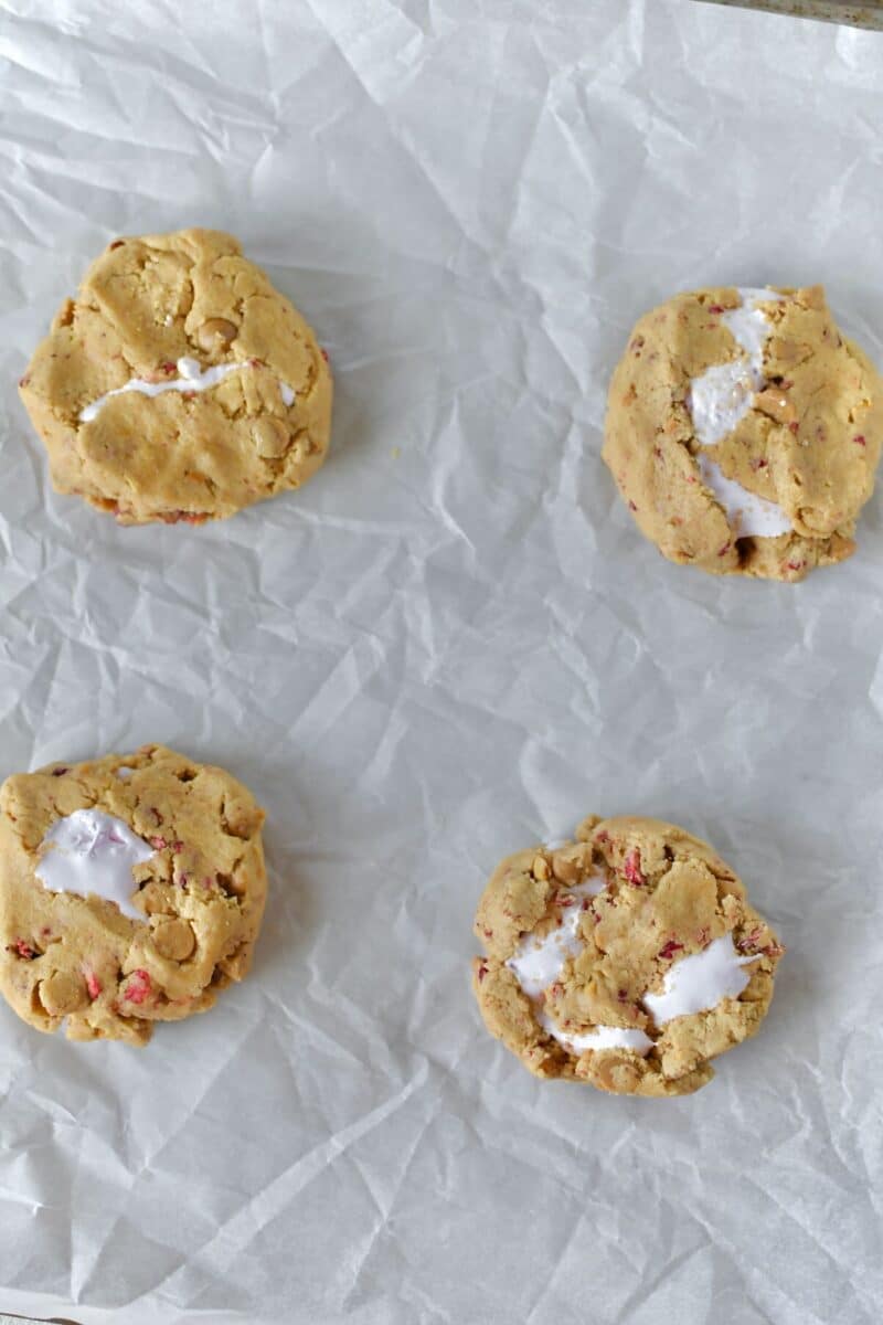 Closed up cookies, with marshmallow cream inside, on a sheet pan, slightly flattened, ready to bake.