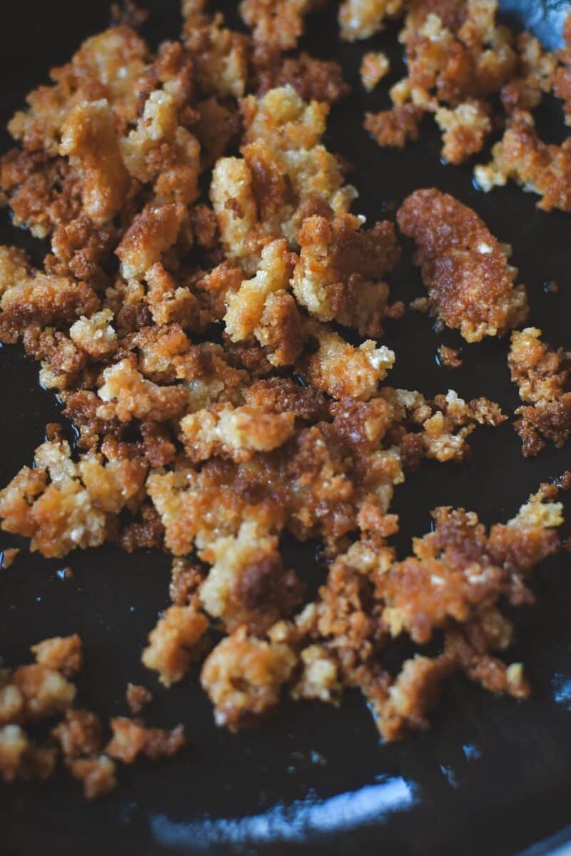 Toasting bread crumbs and parmesan cheese in a skillet till browned and crispy.