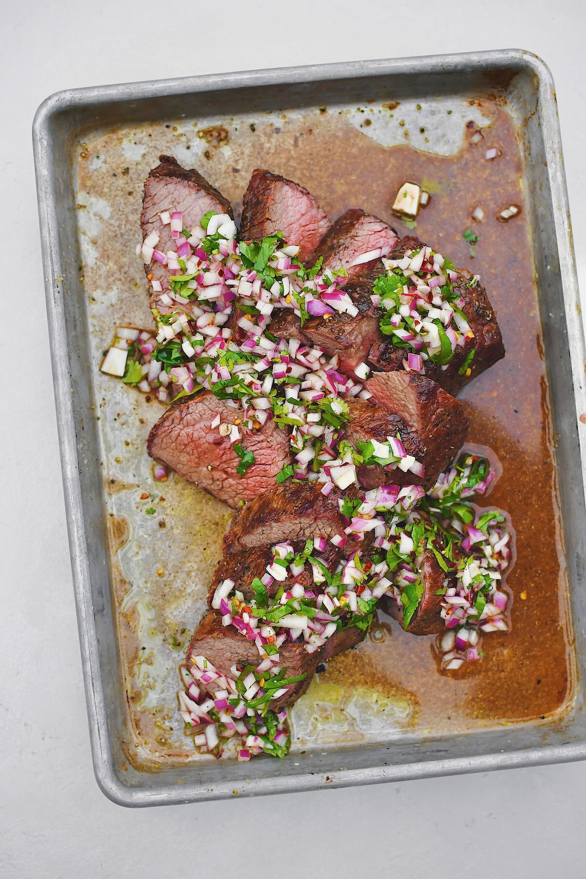 Tri-Tip, sliced against the grain, in two different directions, as is common with this cut of meat. Topped with an onion, cilantro, and vinegar relish.