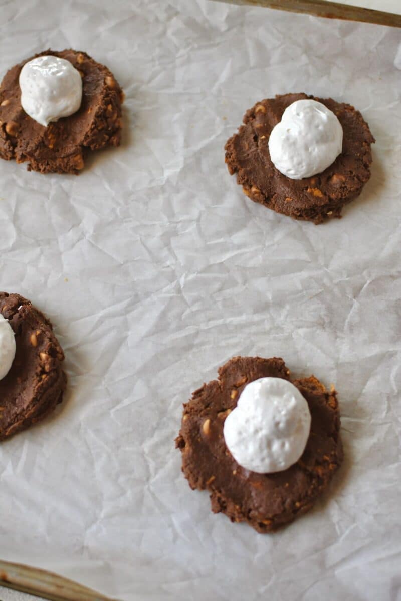 Adding the marshmallow cream to the flattened cookies.