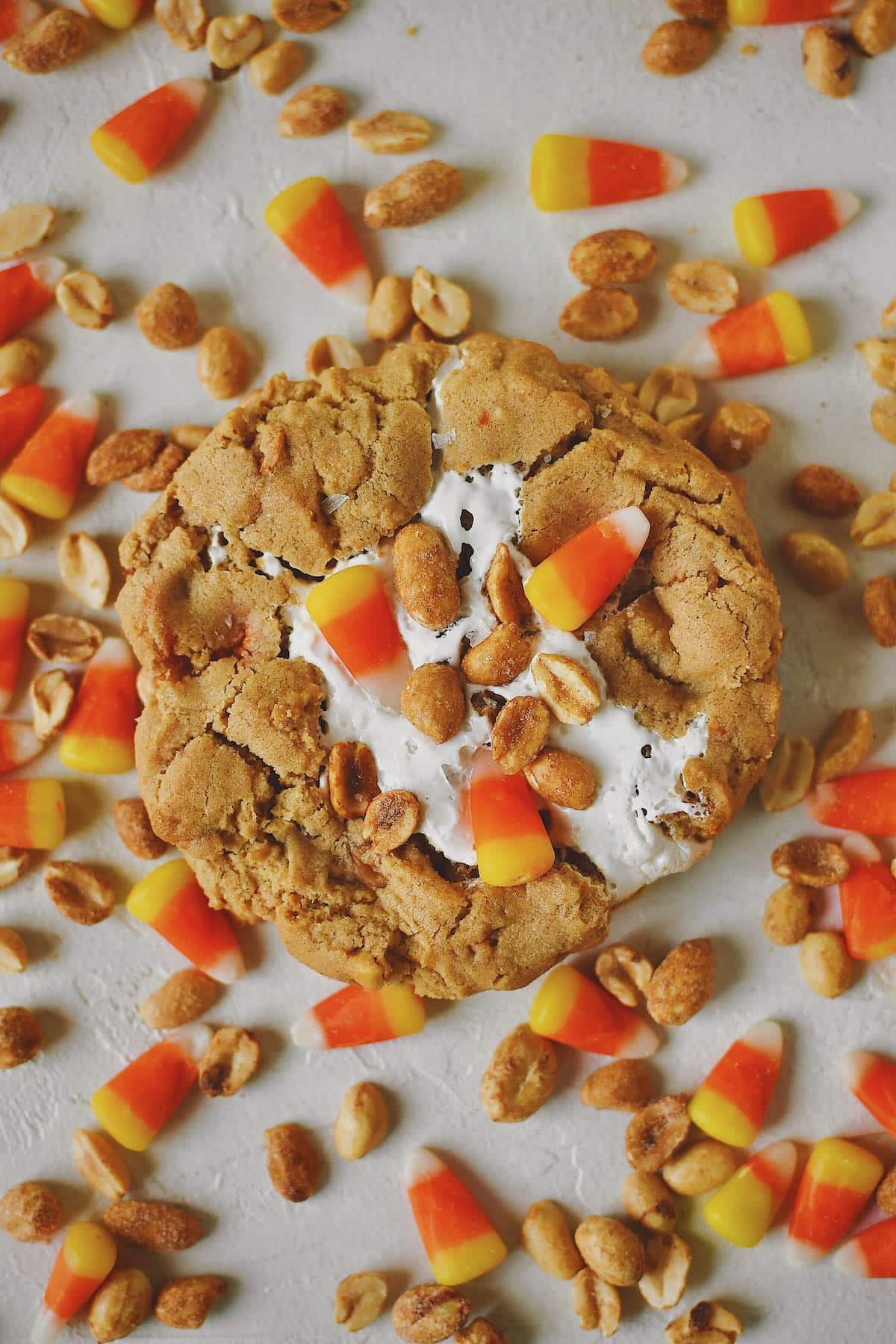 Finished Candy Corn Cookies laid out on a table with candy corn and peanuts snack mix under them, ready to eat!