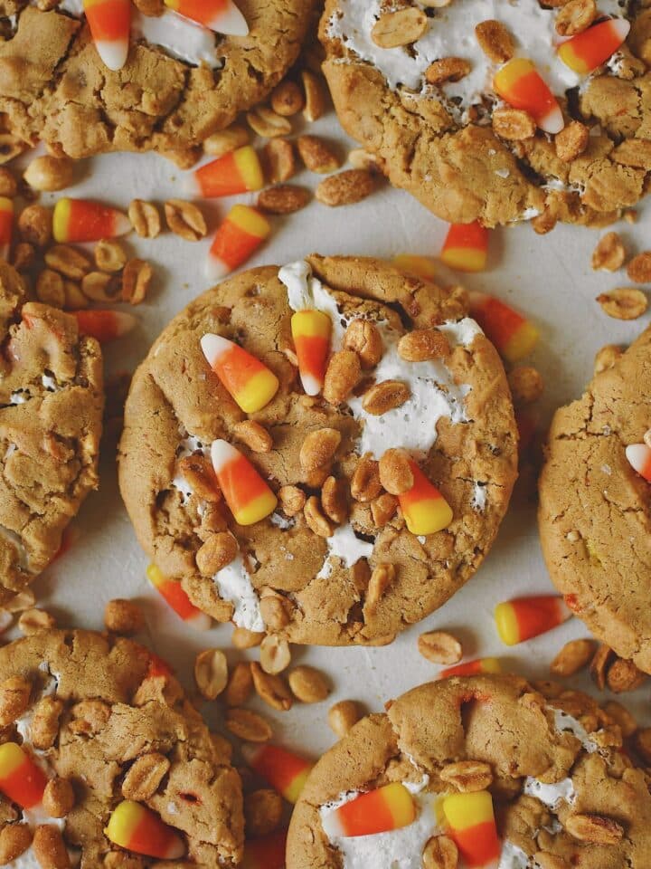 Finished Candy Corn Cookies laid out on a table with candy corn and peanuts snack mix under them, ready to eat!