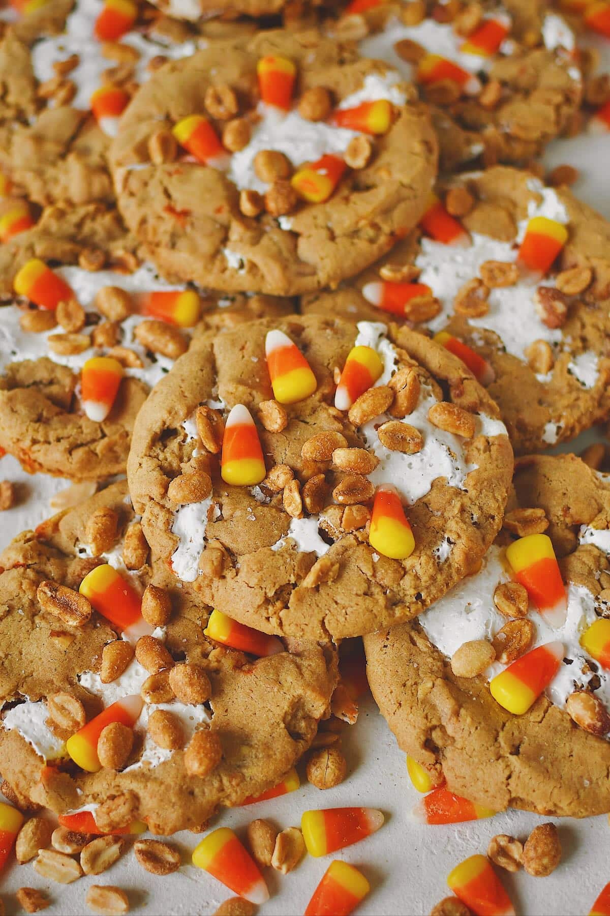 Finished Candy Corn Cookies laid out on a table with candy corn and peanuts snack mix under them, ready to eat!