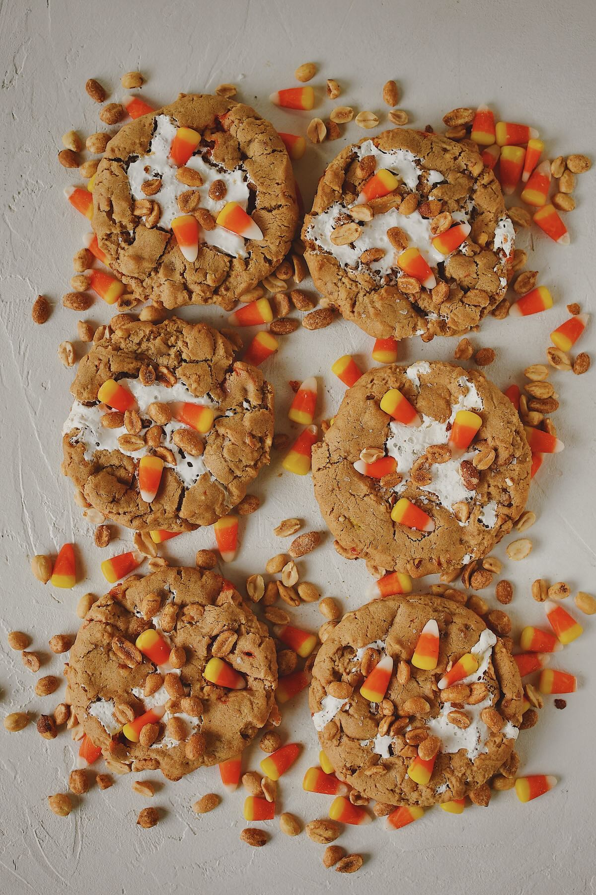 Finished Candy Corn Cookies laid out on a table with candy corn and peanuts snack mix under them, ready to eat!