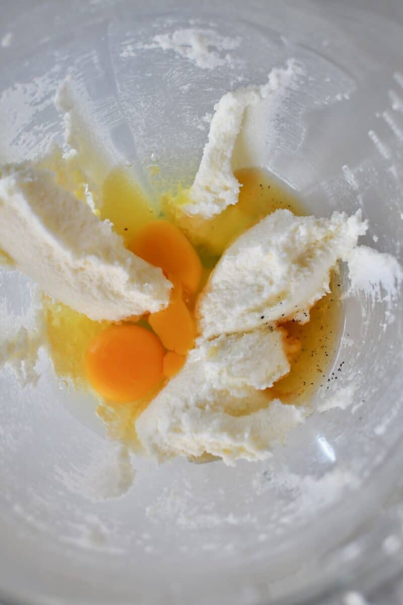 Adding the eggs and vanilla to the creamed butter and sugar.