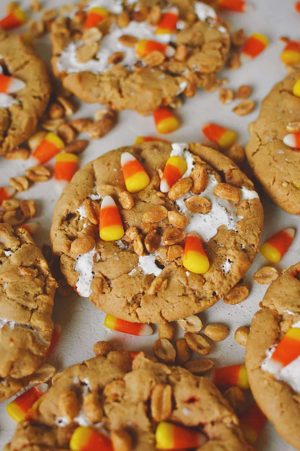 Finished Candy Corn Cookies laid out on a table with candy corn and peanuts snack mix under them, ready to eat!