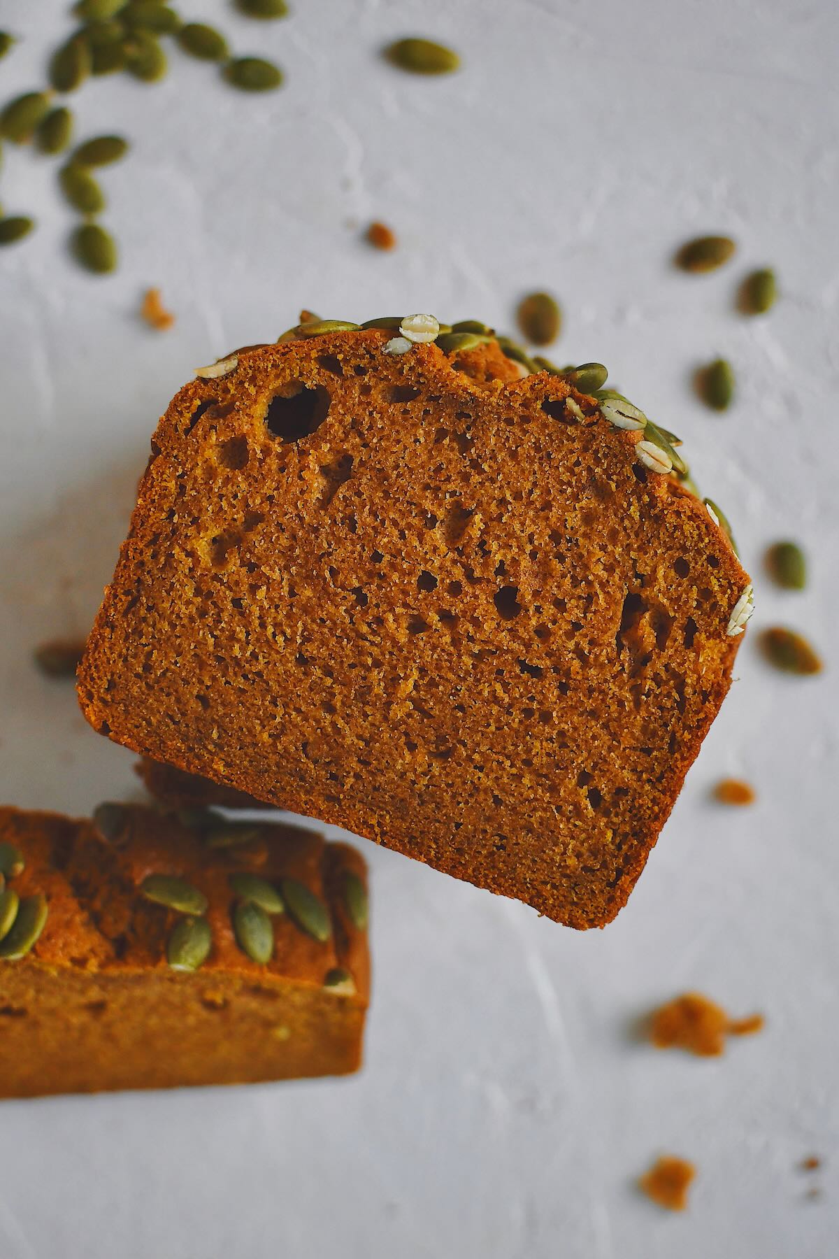 A single slice of Pumpkin Spice Bread, with another leaning next to it.