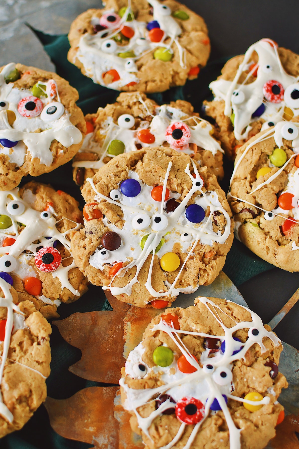 Peanut Butter Monster Cookies fresh from the oven, with melted marshmallow spread over them to look like spider webs and monster eyes added.