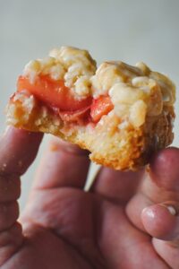 Holding one of the White Peach Bars, after taking a bite out of it.