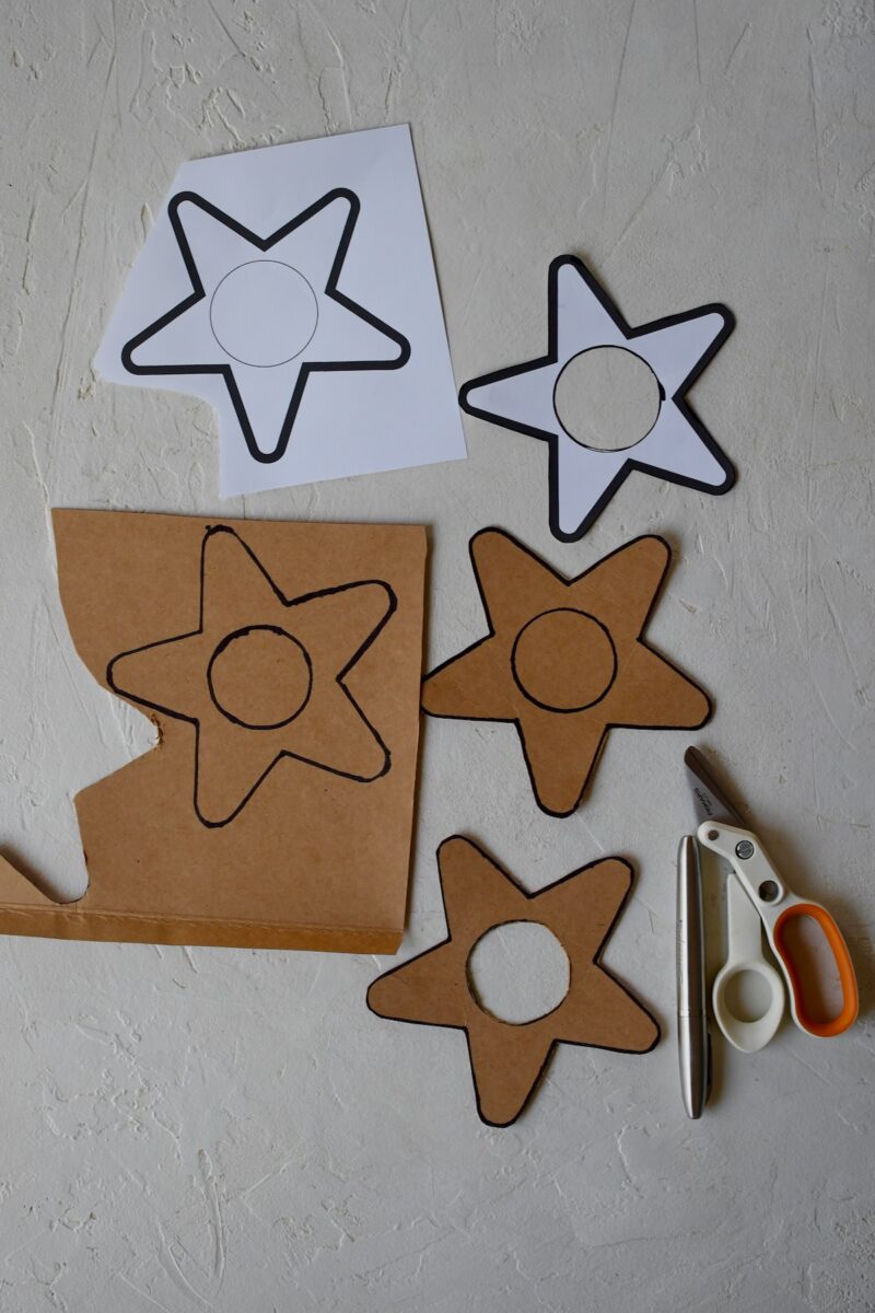 Using a printed star template that has been cut out, to trace and cut out cardboard stars. Example showing each stage.