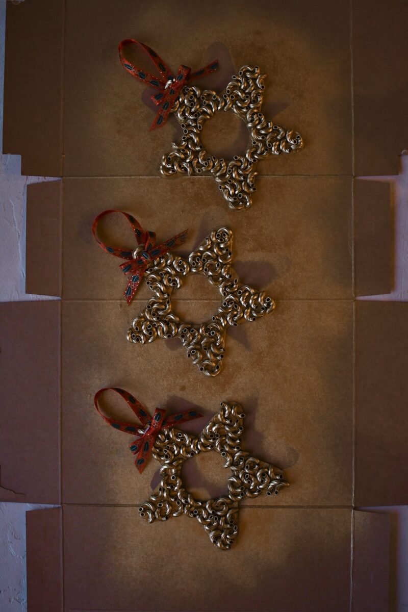Macaroni pasta has all been glued on, after spray painting gold and adding a ribbon for hanging and a bow.