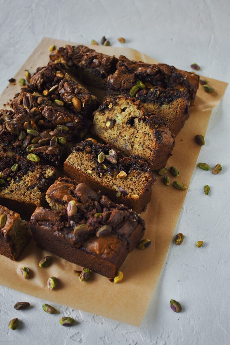 Pistachio Banana Bread all sliced with pistachios spread around it.