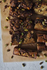 Looking down into a slice of banana bread topped with pistachios.