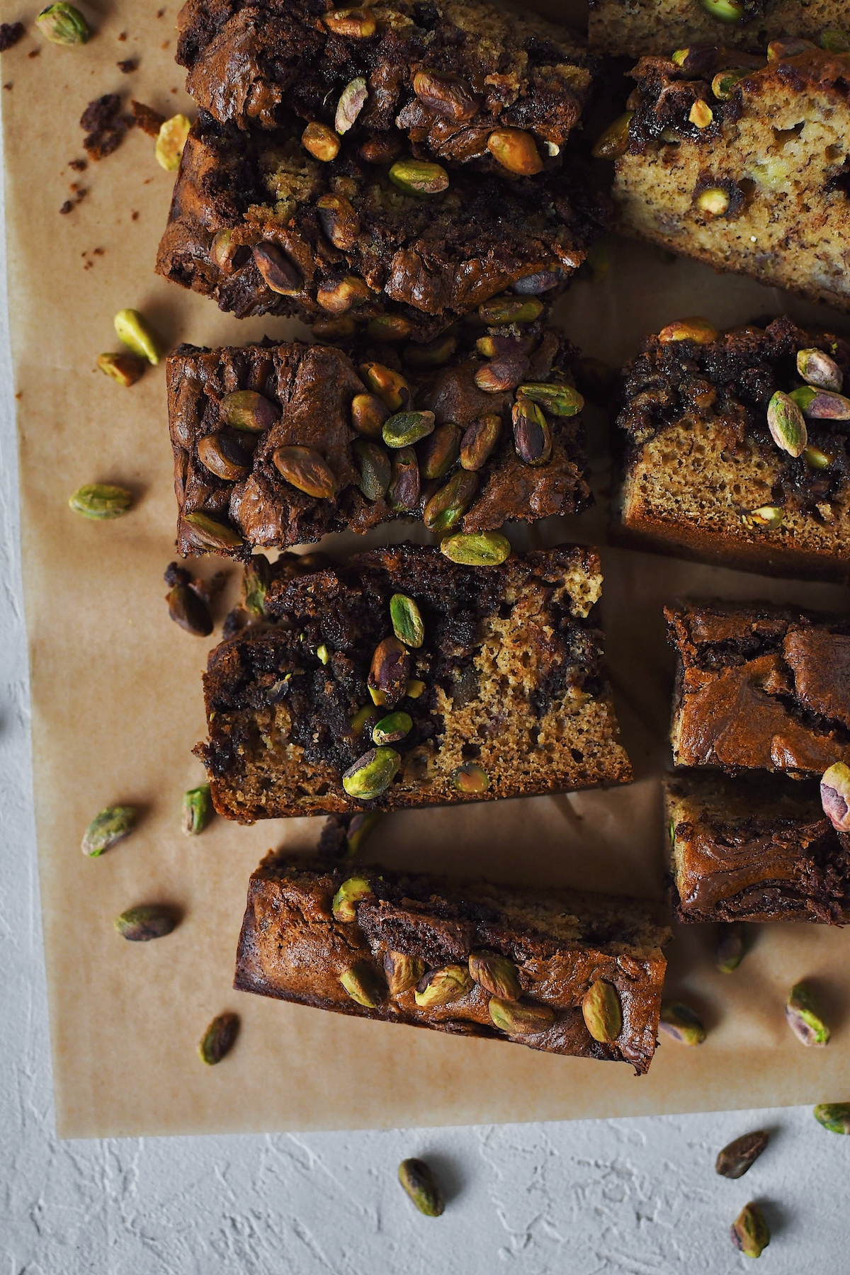 Looking down into a slice of banana bread topped with pistachios.