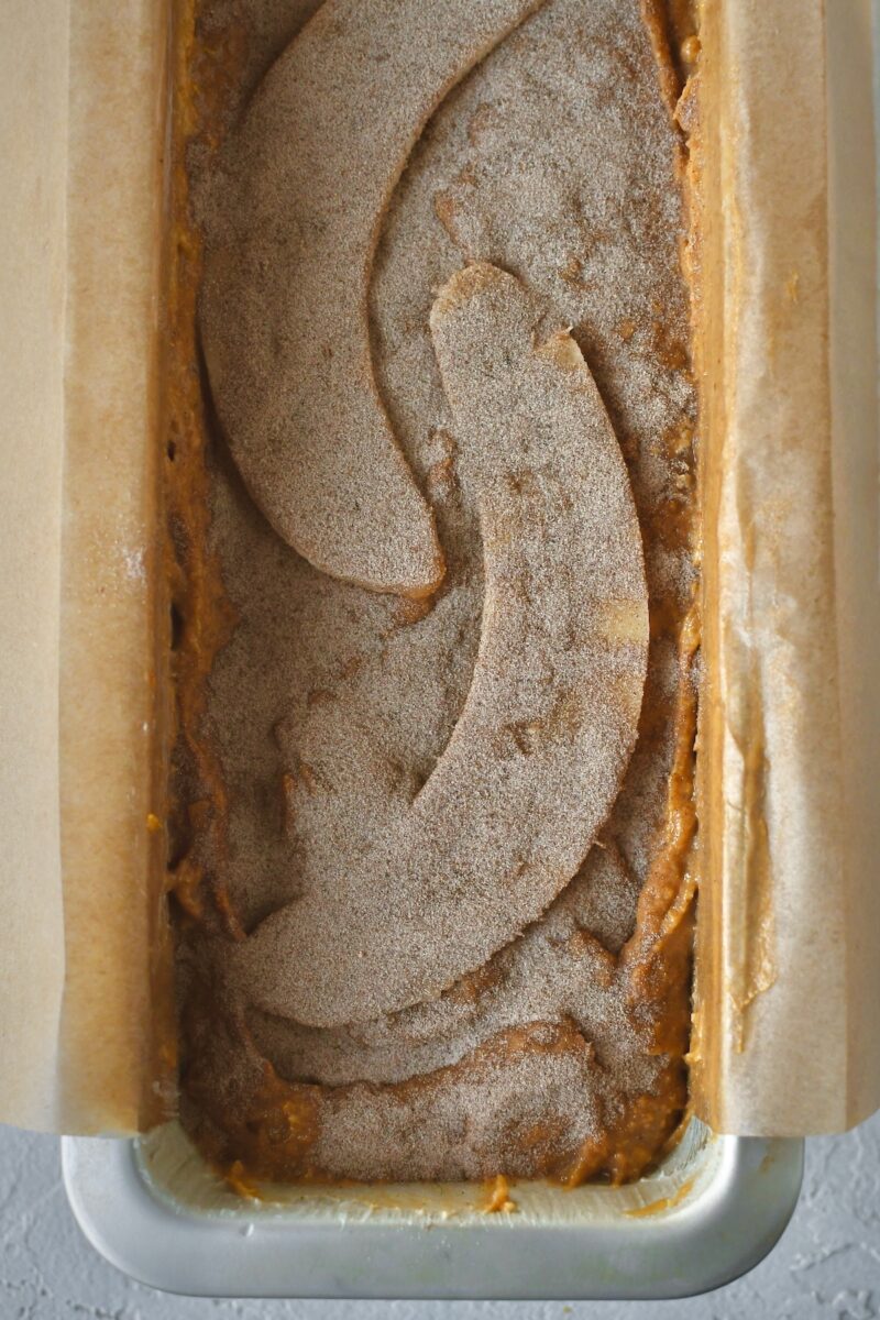 Batter and halved banana topped with cinnamon sugar before baking.