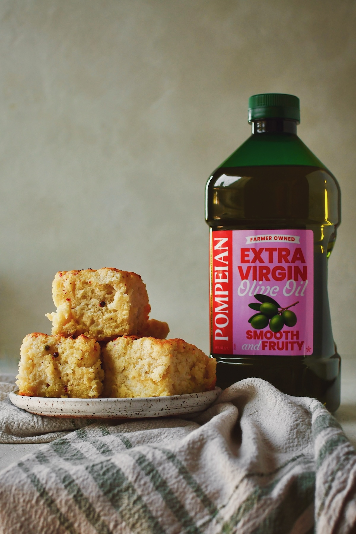 Cooked Olive Oil Swim Biscuits on a plate next to a bottle of olive oil.