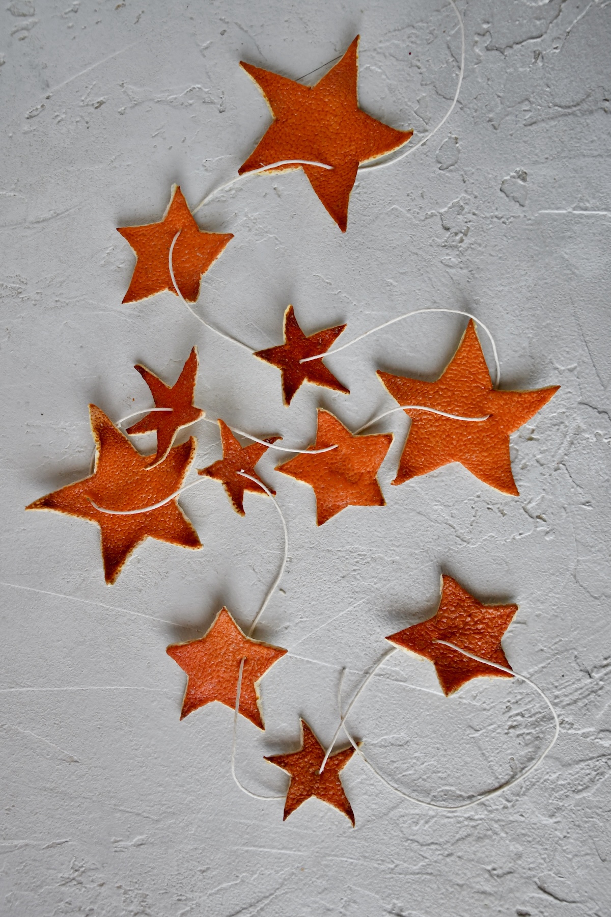 Orange Peel Star Garland strung up on twine, laid out and ready to be placed on a tree.