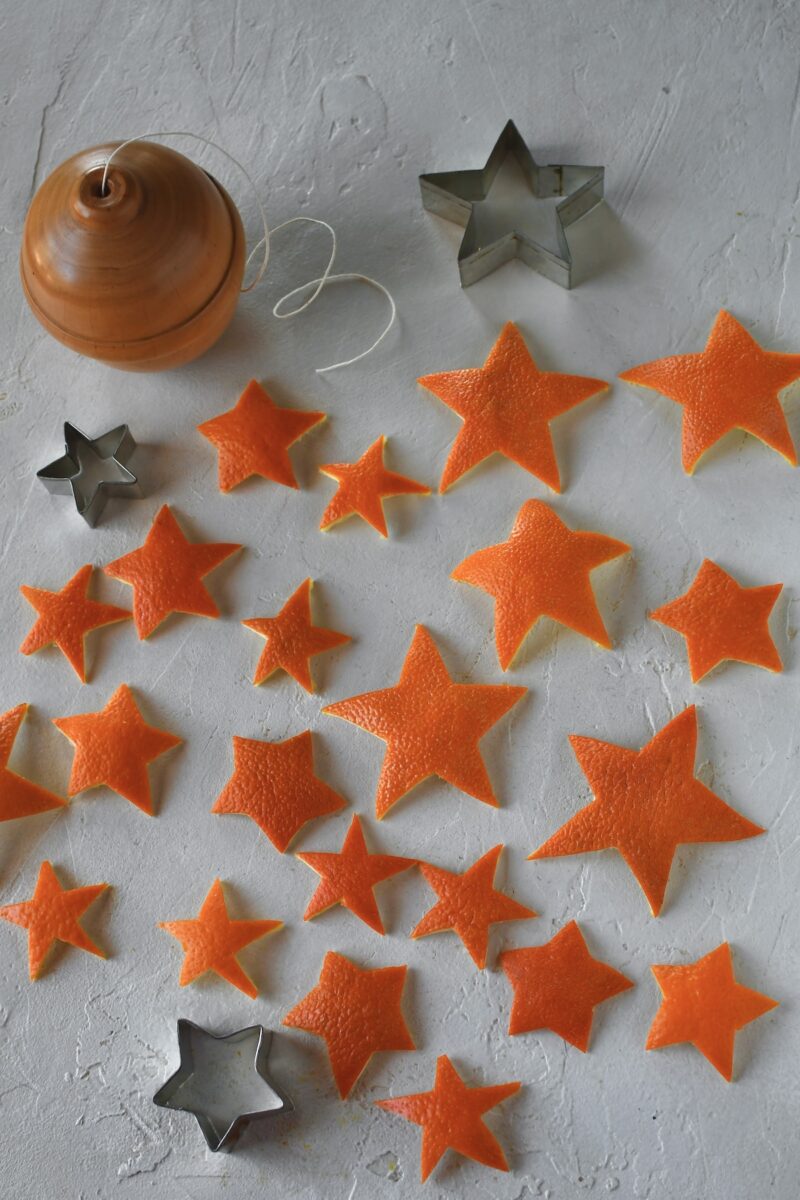 Cut out orange peel stars laid out on a table, in various sizes.