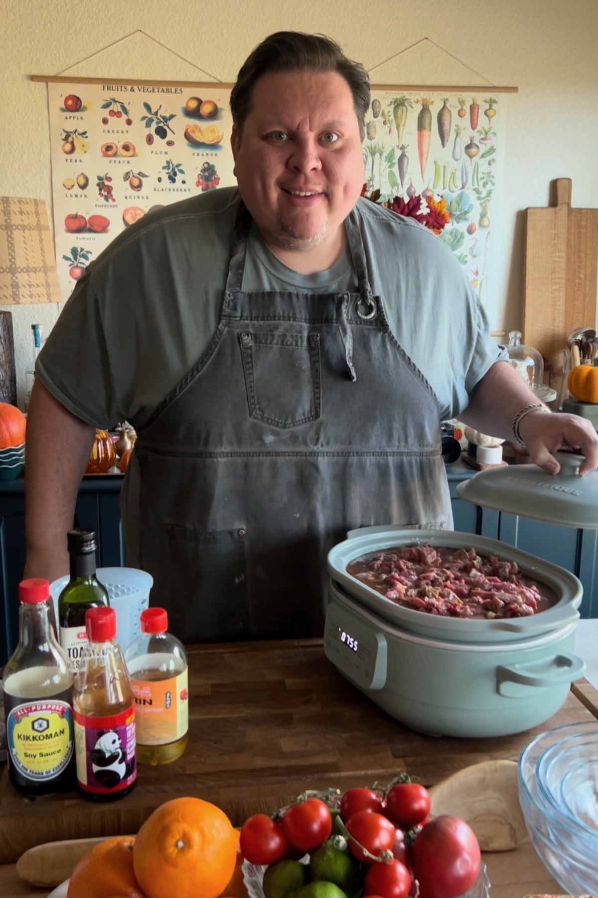Kendell standing in his kitchen with the ingredients needed to make Slow Cooker Beef and Broccoli.
