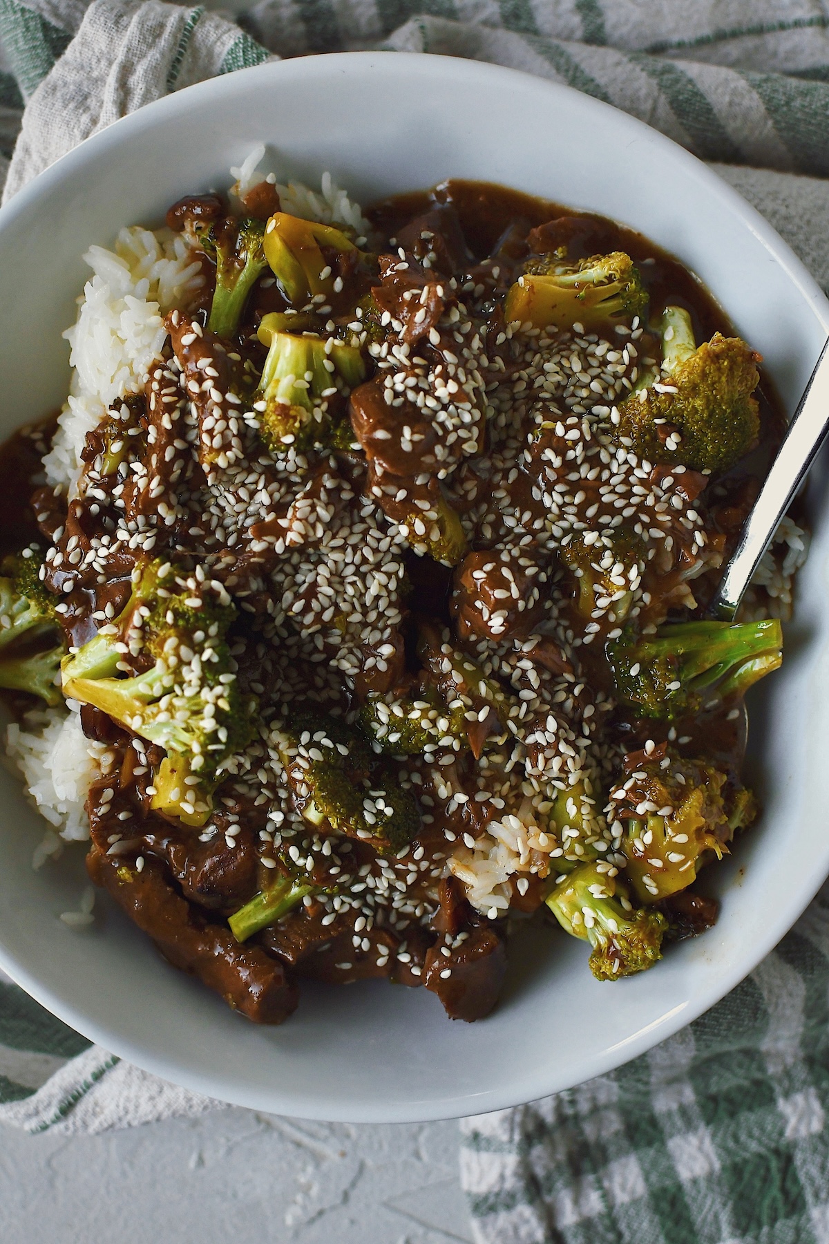 Looking down into a bowl of Slow Cooker Beef and Broccoli served over rice.