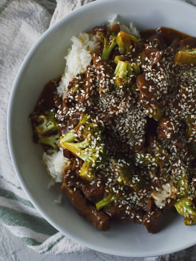 Slow Cooker Beef and Broccoli in a bowl, served over rice.